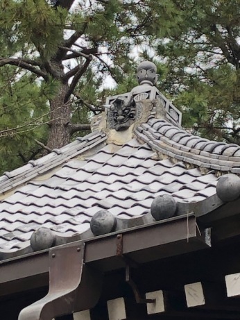 A demon (oni) looks out from the secondary temple's roof
